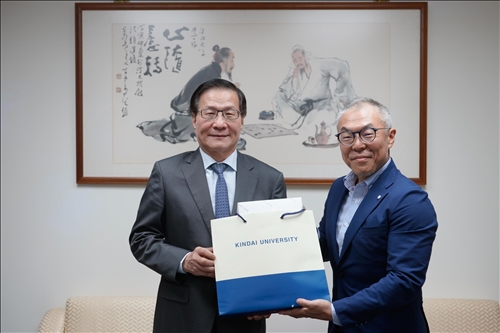 2-世耕石弘總務部長(右)贈送葛煥昭校長(左)禮品。(馮文星攝影)