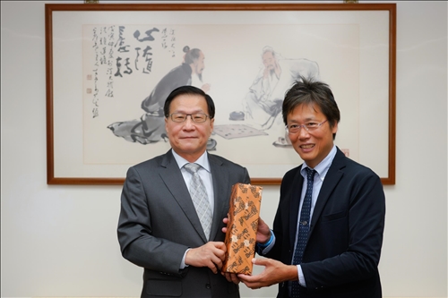 2-安達千波矢教授(右)贈送葛煥昭校長(左)禮品。(馮文星攝影)