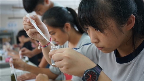 鳳林國中的同學專注地將水溶液滴入小玻璃瓶內