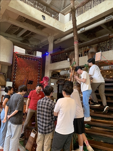 包院長介紹店內原住民文化特徵的擺設品。