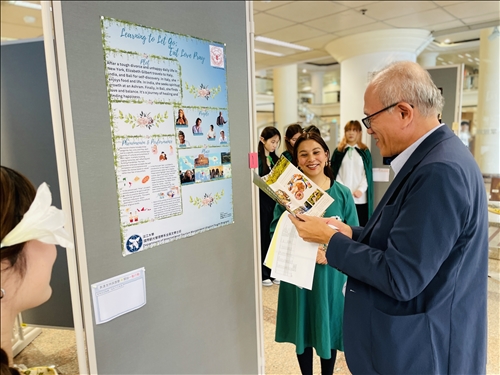 外交系陳建甫副教授欣賞國際學生《一個人的旅行》個案組的遊程設計摺頁。