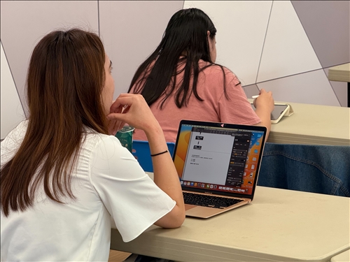 學生運用電腦同步記錄課程內容，展現高度參與與學習熱情。