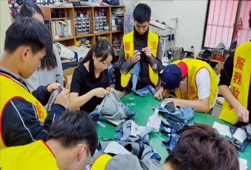 學生向修惜站教師學習如何拆解牛仔褲