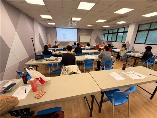 教室全景呈現互動式教學現場，學員積極記錄與提問，展現高度參與。