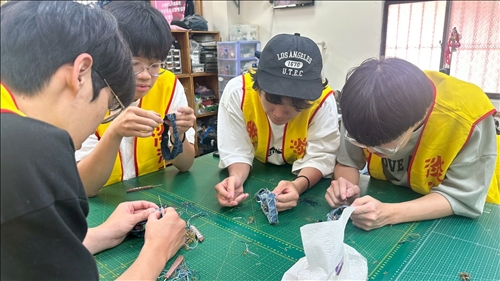 學生協助拆解廢棄牛仔褲的褲頭，重新拆解後可再製成新的產品重新利用