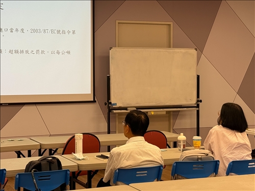 白板前兩位學員聚精會神閱讀投影片內容，掌握歐盟法規的具體罰則項目。