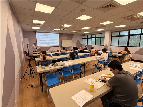 學員們聚精會神聽講並查看講義，教室氛圍專注且實務導向。