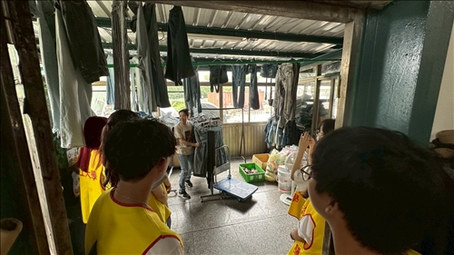 謝總幹事帶領學生了解廢棄牛仔褲回收後的洗滌與曝曬工作