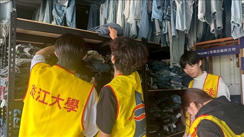 學生協助整理廢棄牛仔褲，依照不同的顏色進行分類