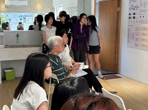 黃瑞茂老師查閱學生教案與學習材料，說明如何由預期結果反向規劃評量及學習活動。